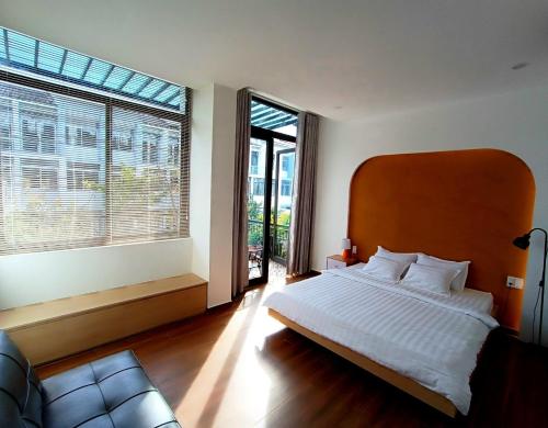 a bedroom with a large bed and large windows at Lullaby homestay in Hue