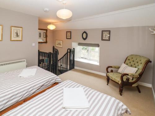 1 Schlafzimmer mit 2 Betten, einem Stuhl und einem Fenster in der Unterkunft Cosy Cottage in Burford