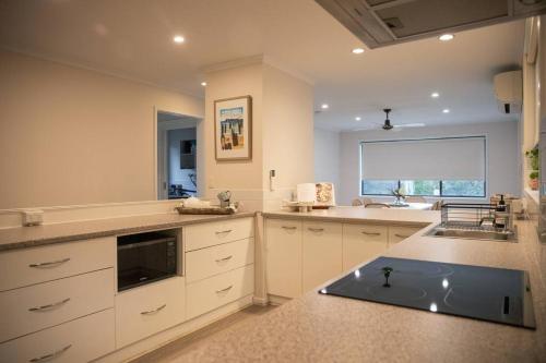 a large kitchen with white cabinets and a sink at Clifton Springs Home - Pet Friendly in Clifton Springs