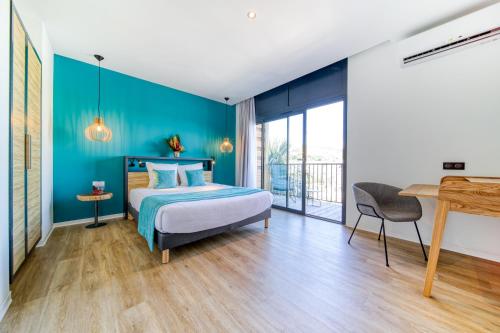a bedroom with a bed with a blue wall at Résidence Santa Apolonia in Saint-Leu