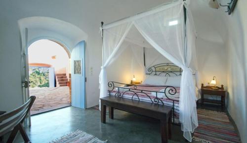 a bedroom with a canopy bed and a wooden bench at Abramis Rooms in Mitáta
