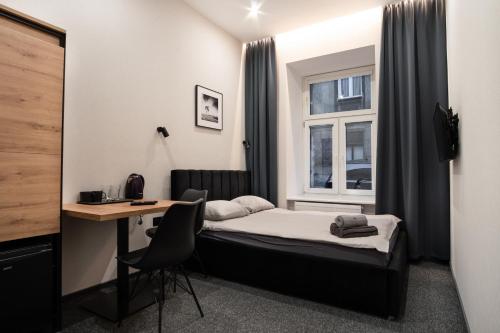 sypialnia z łóżkiem, biurkiem i oknem w obiekcie Dream Aparts - Piotrkowska 33 w Łodzi