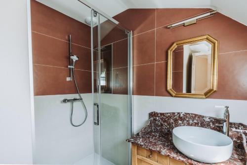 La salle de bains est pourvue d'un lavabo et d'une douche en verre. dans l'établissement Château Belle Epoque - Chambres d'Hôtes & Gîtes, à Linxe