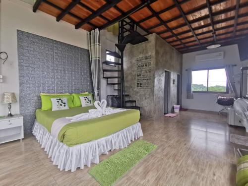 1 dormitorio con 1 cama grande con almohadas verdes en บ้านฮิมนาปัวรีสอร์ท en Pua
