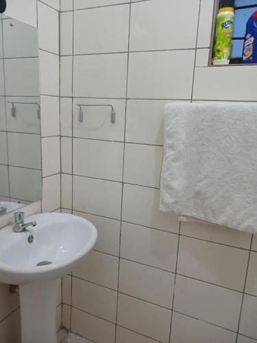 a white bathroom with a sink and a towel at HavenlyView Airbnb in Nairobi