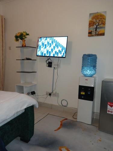 a room with a bed and a television on a wall at HavenlyView Airbnb in Nairobi