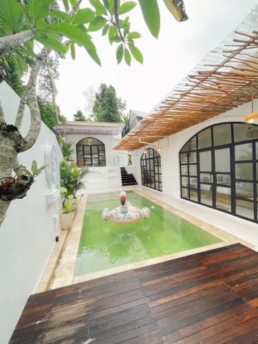 un hombre en una piscina en una casa en Sampai Villa Santiva en Pedes
