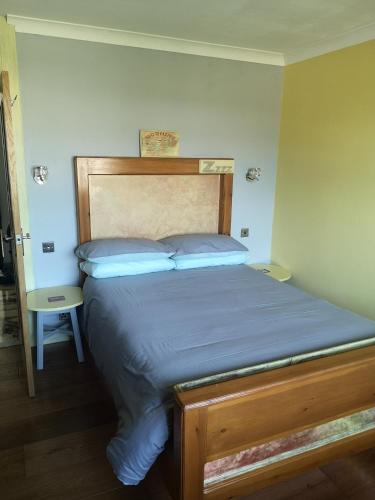 uma cama com uma cabeceira de madeira num quarto em Cedar Top em Manston