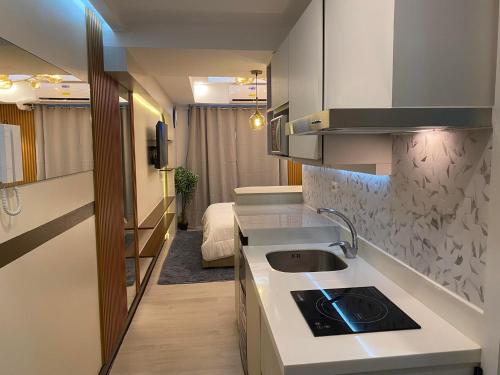 a small kitchen with a sink and a stove at BALI TOWER AZURE NORTH RESIDENCES in Lagundi