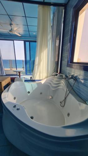 a bath tub in a room with a view of the ocean at villa haroun in Dahab