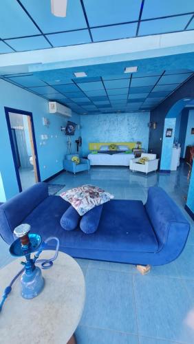a living room with a blue couch and a table at villa haroun in Dahab