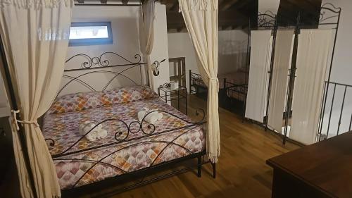 - une chambre avec un lit en métal et des rideaux dans l'établissement La Quercia incantata, à Castiglione del Lago