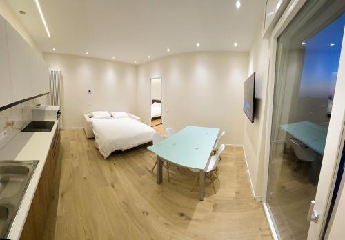 a kitchen with a table and a bed in a room at Attici Alba e Tramonto Ospedale e Vista in Brescia