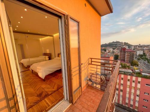 a balcony with a bed and a view of a city at Attici Alba e Tramonto in Brescia