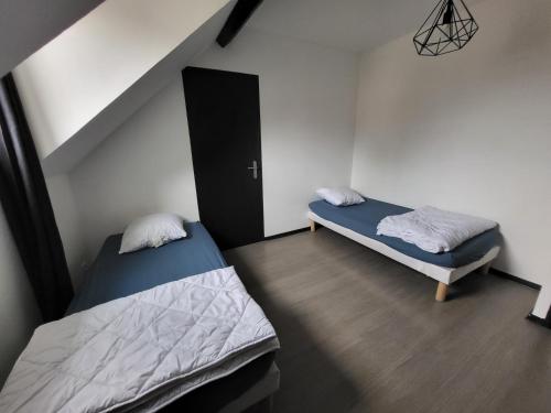 - 2 lits dans une petite chambre avec un escalier dans l'établissement APPARTEMENT DE GUISE 10, à Valenciennes