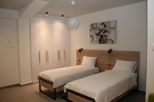 2 Betten in einem Zimmer mit weißen Wänden in der Unterkunft Maks Osijek in Osijek