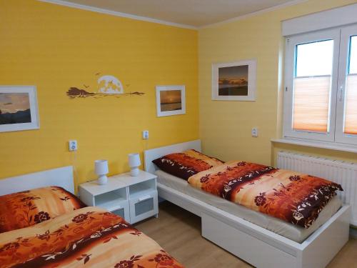 a bedroom with two beds and a yellow wall at Ferienwohnung Benkertshof 