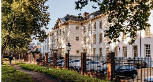 eine Reihe von Autos, die vor einem weißen Gebäude geparkt sind in der Unterkunft Grand Hotel Karel V in Utrecht