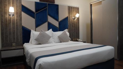 a bedroom with a large bed with blue and white pillows at Mabeet Al-Khobar in Al Khobar
