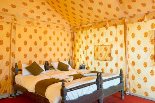 a bedroom with a bed in a tent at Bluebird Desert Resort in Jaisalmer