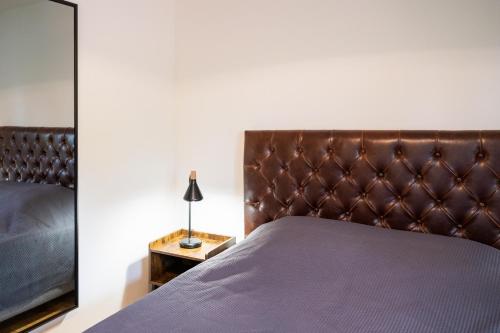 a bedroom with a bed with a brown headboard at Château Belle Epoque - Chambres d'Hôtes & Gîtes in Linxe