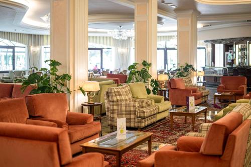 a lobby with couches and chairs and tables at Hotel Apollo Terme in Montegrotto Terme
