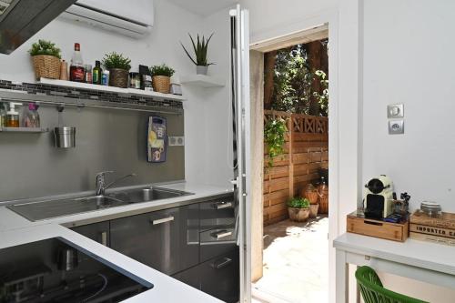 una cucina con lavandino e una porta per un cortile di Studio Cosy " La Tarente Dorée " a Fréjus