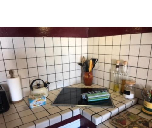 a tiled kitchen counter with a stove top oven at VV YELYMAR. PLAYA DE ALOJERA in Alojera