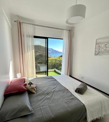 een slaapkamer met een groot bed en een groot raam bij Santa Catarina by Olá Madeira in Funchal