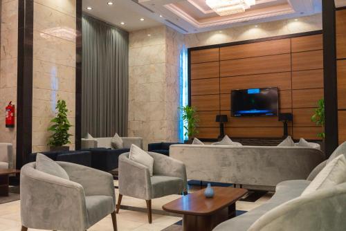 a waiting room with couches and a tv on a wall at La Cordia Hotel Apartment لاكورديا للشقق الفندقية in Adh Dhahirah