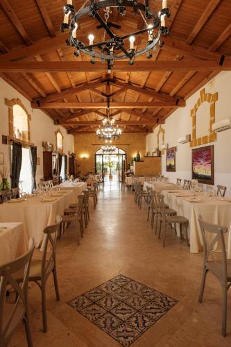 a dining room with tables and chairs and a chandelier at Case Di Latomie in Castelvetrano Selinunte