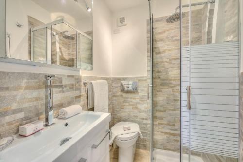 La salle de bains est pourvue de toilettes et d'une douche en verre. dans l'établissement Studio La Borracina Mountain View - Happy Rentals, à Sauze dʼOulx