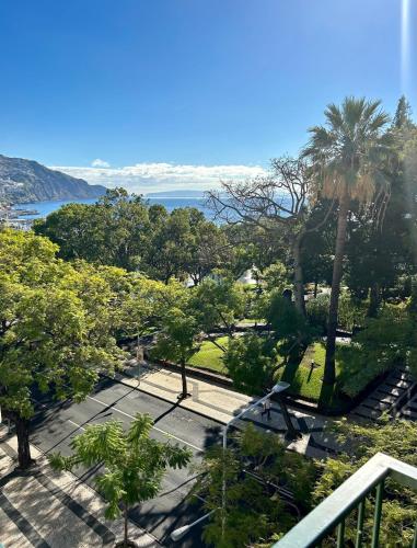 uitzicht op een park met palmbomen en de oceaan bij Santa Catarina by Olá Madeira in Funchal