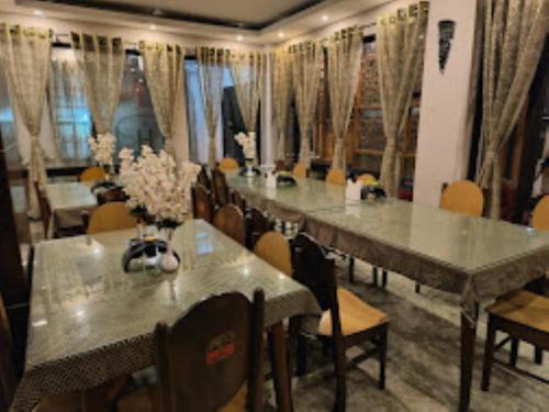 een eetkamer met tafels en stoelen met bloemen erop bij Retreat Hotel Samden, Darjeeling in Darjeeling