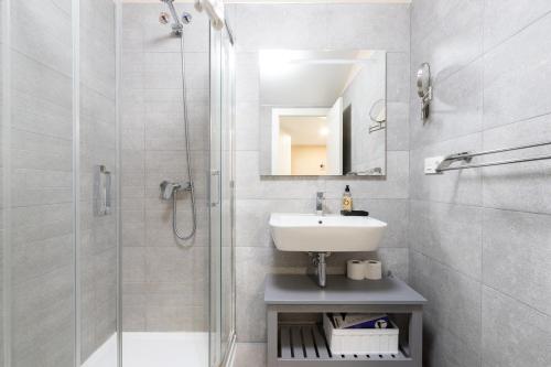 y baño blanco con lavabo y ducha. en INSIDEHOME Apartments - La Casita de Montse, en Palencia