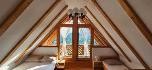 a attic room with two beds and a window at Wine Panorama house in Jastrebarsko