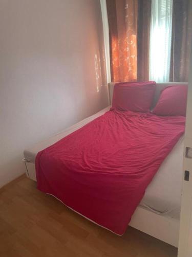 Schlafzimmer mit einem Bett mit rosa Bettwäsche und einem Fenster in der Unterkunft Quet Room in 3 bedrooms flat,3 min to Metro, free parking,Supermarket near in Frankfurt am Main