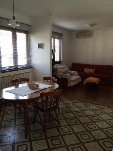 a living room with a table and chairs and a couch at Apartment Bogdanovic in Fažana