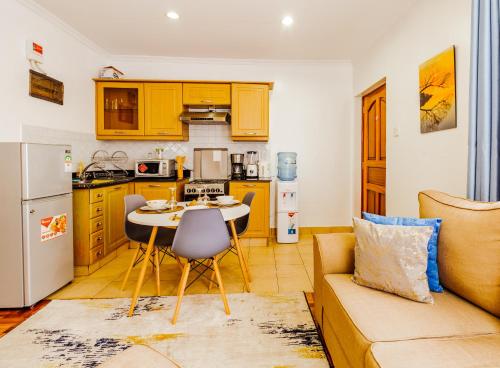 una cucina e un soggiorno con un divano e un tavolo di Caribbean Homes By Edmor Suites a Nairobi