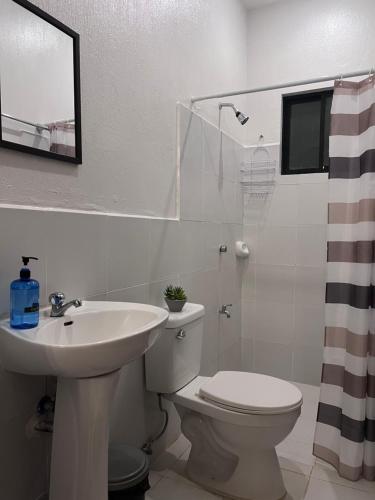 ein weißes Bad mit einem Waschbecken und einem WC in der Unterkunft Casa Via: Cozy 3 Bedroom Home in Bacolod with Parking in Bacolod City