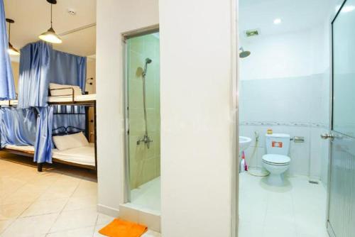 a bathroom with a shower and a toilet and a bunk bed at Violet Star Hotel and Spa in Ho Chi Minh City