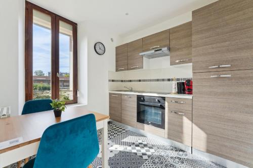 une cuisine avec une table en bois et des chaises bleues dans l'établissement Budget appart avec parking au centre-ville, à Charleville-Mézières