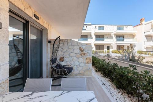 a balcony with a table and chairs and a building at Amalthia Luxury Suites in Polykhrono