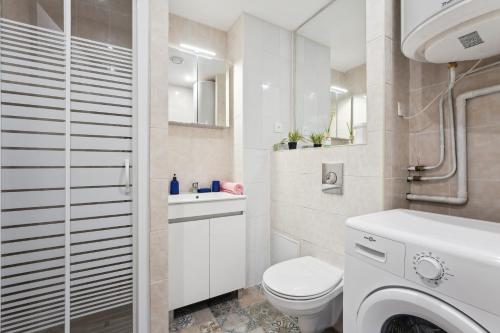 une salle de bain blanche avec des toilettes et un lavabo dans l'établissement Budget appart avec parking au centre-ville, à Charleville-Mézières