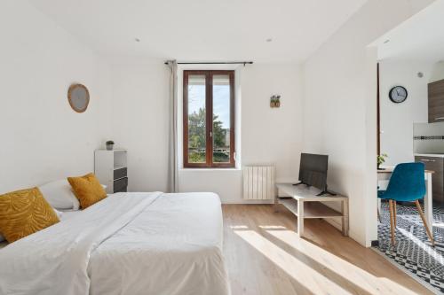 une chambre blanche avec un grand lit et un bureau dans l'établissement Budget appart avec parking au centre-ville, à Charleville-Mézières