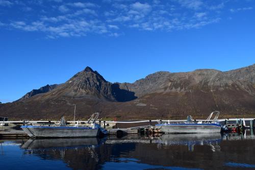 zwei Boote, die an einem Dock mit einem Berg im Hintergrund angedockt sind in der Unterkunft Captains` Sea side 