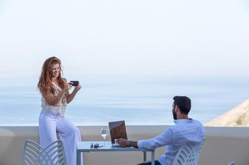 a woman taking a picture of a man with a camera at Skyfall Suites - Adults Only in Pyrgos