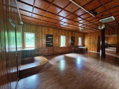 a large room with a wooden floor and wooden walls at OWR Relax - Hostel położony blisko atrakcji turystycznych in Szczytna