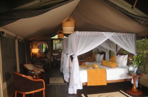 ein Schlafzimmer mit einem Himmelbett in einem Zelt in der Unterkunft Castel Mara Camp in Masai Mara