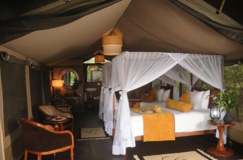 a bedroom with a canopy bed in a tent at Castel Mara Camp in Masai Mara
